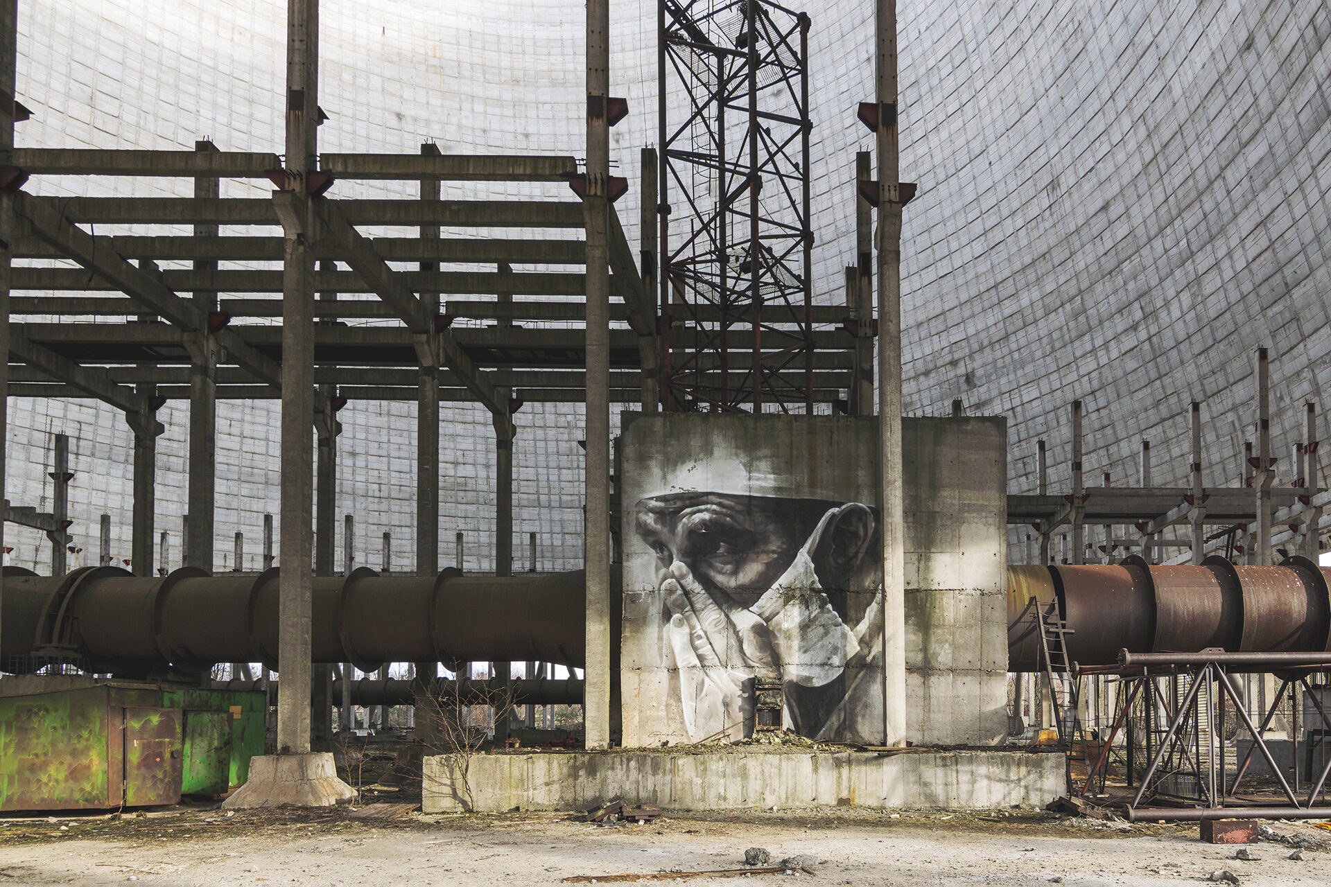 Die Kühltürme sind unvollendete Betonbauten nahe den Baustellen der Reaktoren 5 und 6. (Wandbild von Guido van Helten, Original von Igor Kostin)